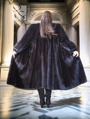 Back view of black mink fur coat with oversized flared hem and wide collar
