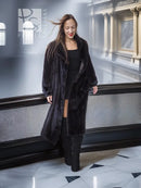 Long black mink fur coat with wide collar; worn over a dark dress.
