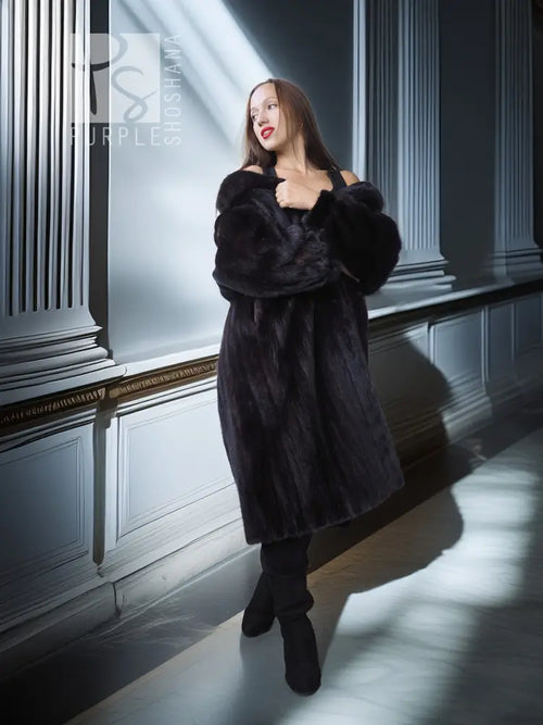 Black mink fur coat with fox fur collar, side view holding lapel