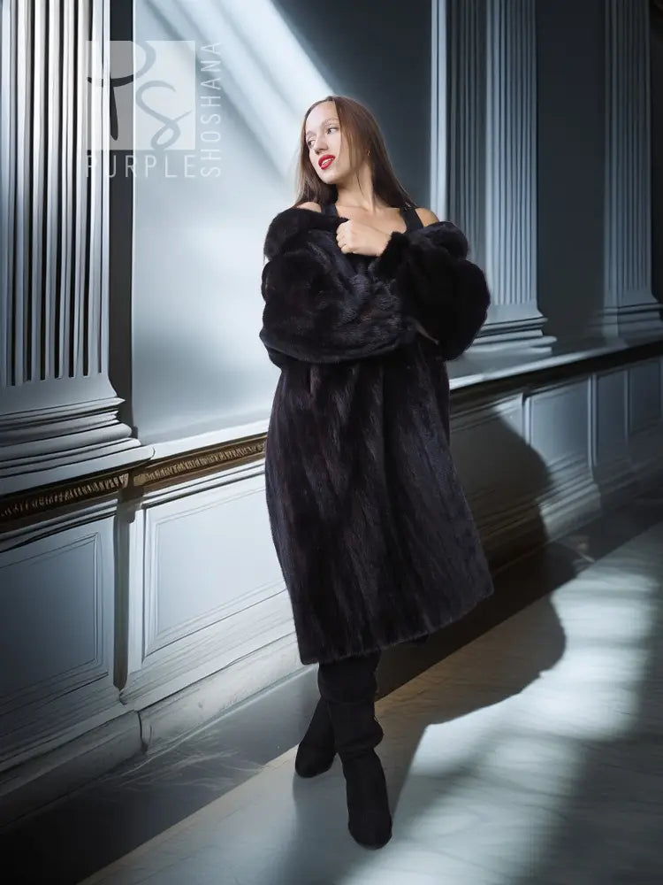 Black mink fur coat with fox fur collar, side view holding lapel