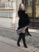 Black mink fur coat with long sleeves, front buttons, and knee-length hem.