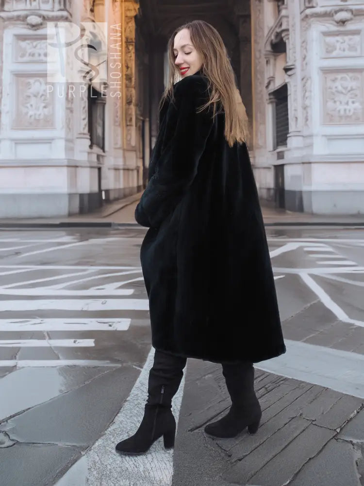 Dark mink fur coat with long sleeves and straight hem, side view on street.