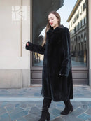 Dark mink fur coat with long sleeves and button-front, knee length.