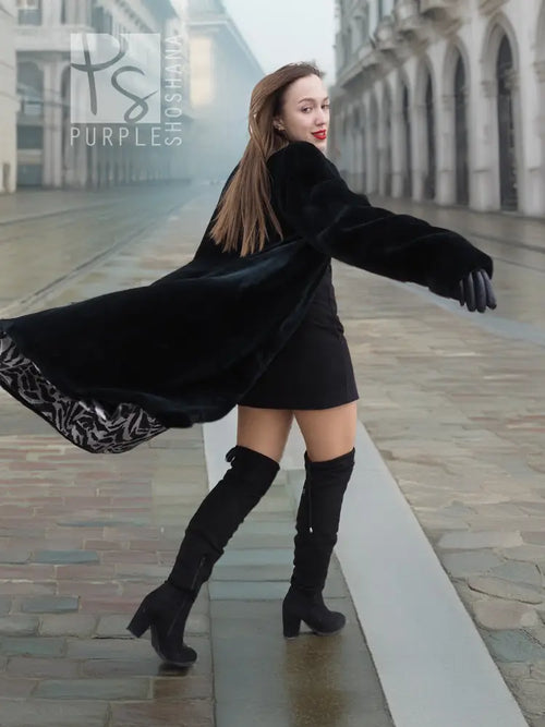 Dark mink fur coat with flared hem and long sleeves, arms extended view.
