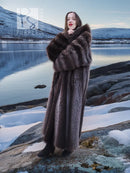 Long dark brown hooded fur coat with cross-front styling, facing the camera.