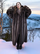 Long hooded dark brown fur coat with full sleeves and plush collar detail.
