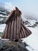 Flared long raccoon fur coat with high collar and dark brown shaggy texture