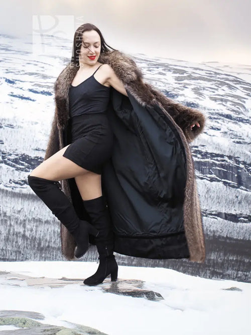Long dark brown raccoon fur coat with large collar and open front over a black dress.