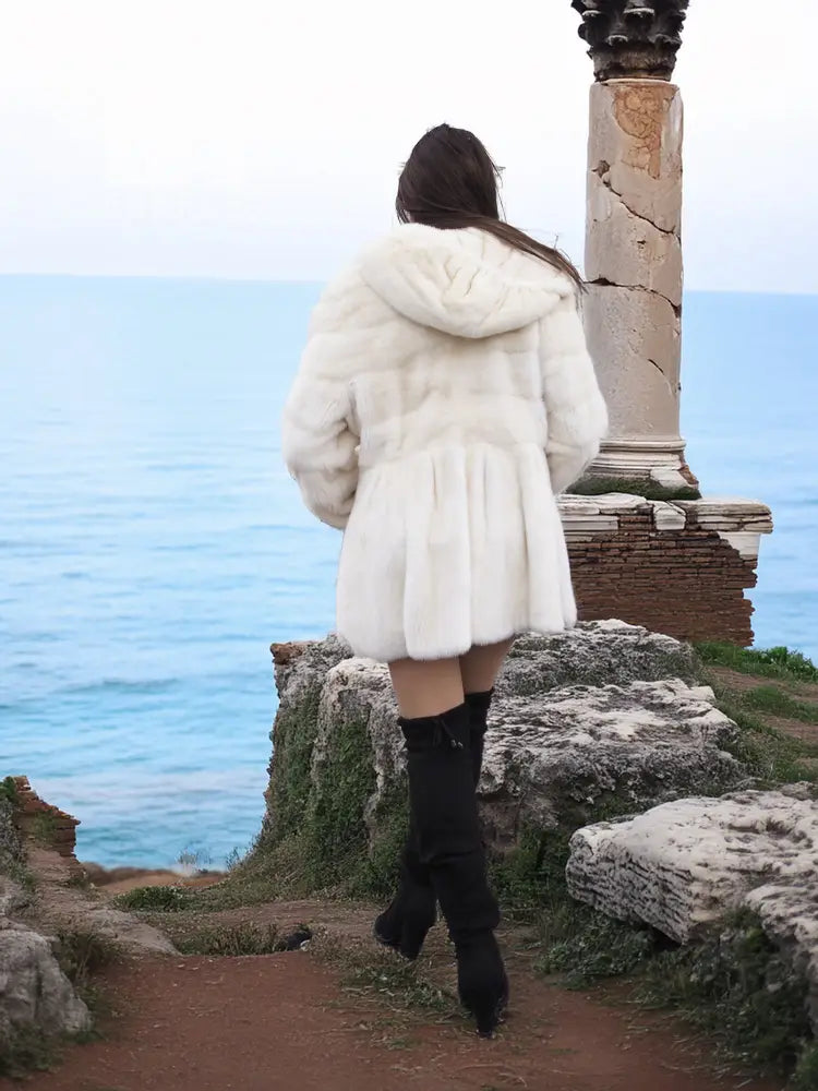 Mink fur hooded coat from back view, hood up and long flared sleeves.