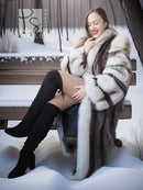 Full-length fur coat with thick cuffs and striped panels, fox-trim collar, worn with boots