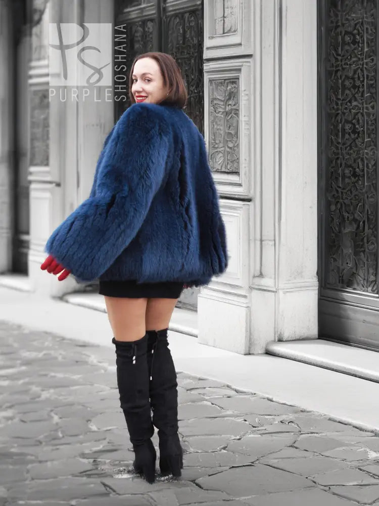 Vibrant blue faux fur jacket with rounded shoulders and long sleeves, side view