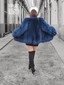Back view of blue fox-fur hooded jacket with flared hem and long sleeves.