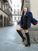 Vibrant blue faux fur jacket with plush long sleeves and side drape, standing view