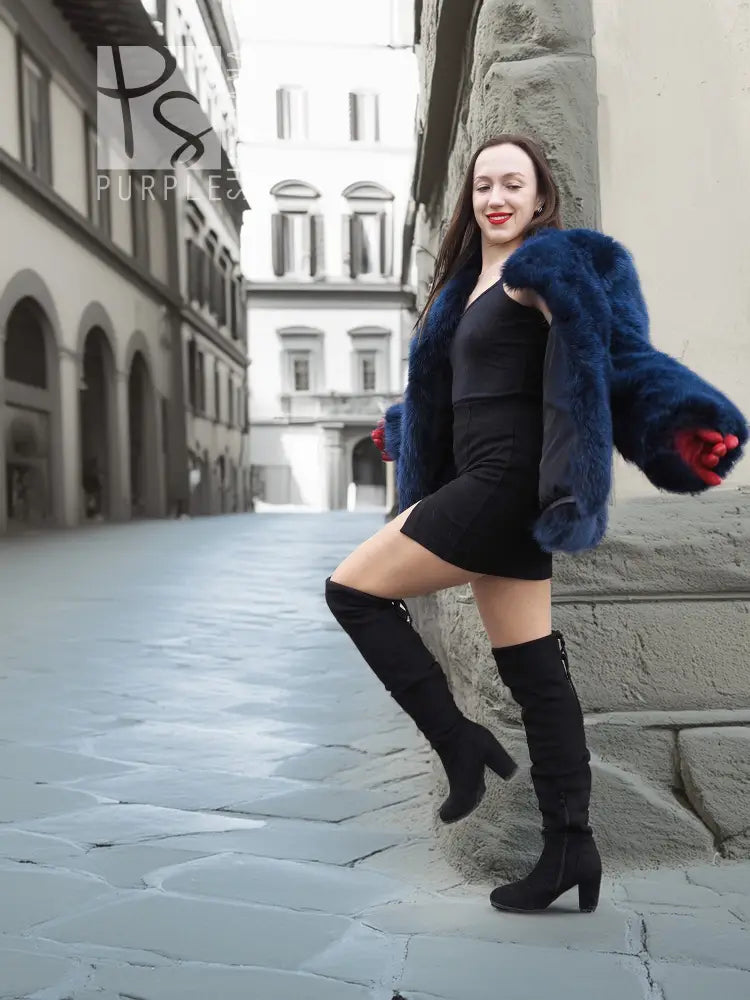 Vibrant blue faux fur jacket with plush long sleeves and side drape, standing view