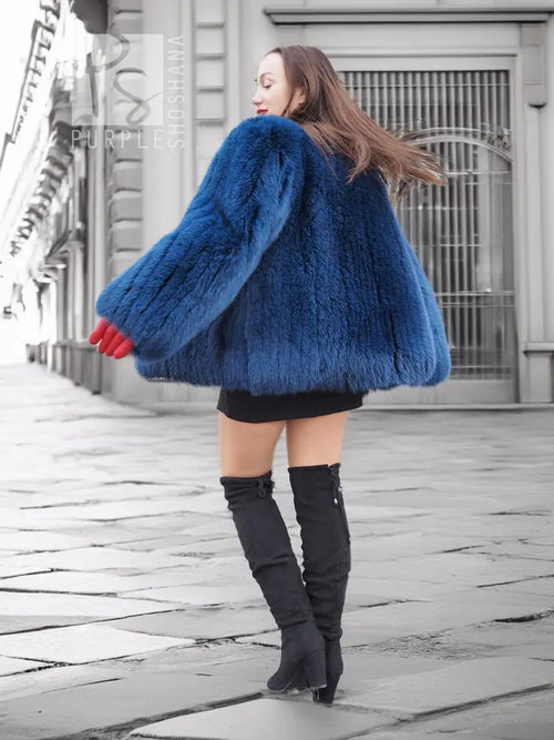 Vibrant blue faux fur jacket with long sleeves and shaggy texture, back view