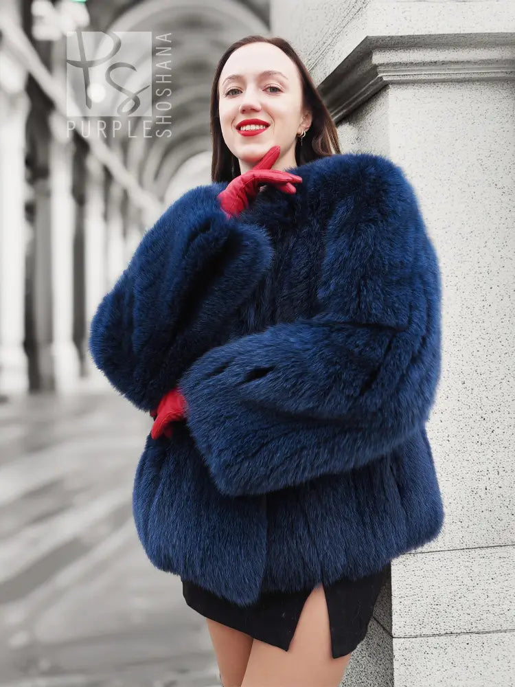 Blue fox-fur jacket with hood and thick collar, long sleeves with ribbed cuffs.