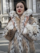 Close-up of spotted plush fur coat collar and shoulders, beige with brown and black spots