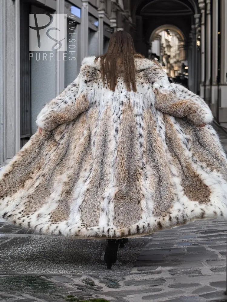 Front view of long spotted plush fur coat with shawl collar, flared hem, beige and dark spots