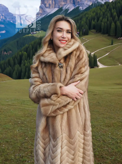Pastel tan mink fur coat with hood, toggle closure, and herringbone patterned body.