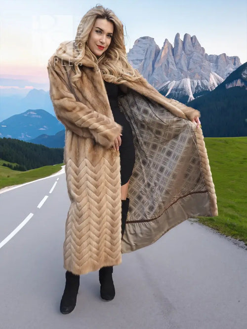 Long tan mink fur coat with chevron pattern and wide draped back panel.