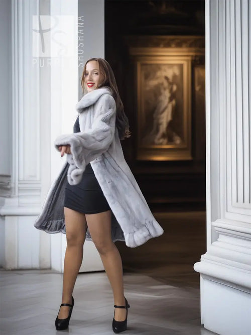 Light gray mink coat with petal collar and sculpted ruffled hem, three-quarter pose