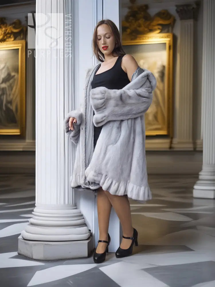 Light gray mink coat with petal collar and sculpted ruffled hem, arms crossed