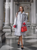 Light gray mink coat with petal-style collar and textured panels, mid-calf length, buttonless front.
