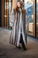 Gray long fur coat with oversized hood and full sleeves, front view in storefront area