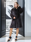 Reversible mink jacket with dark fur collar, button placket, and knee-length fit