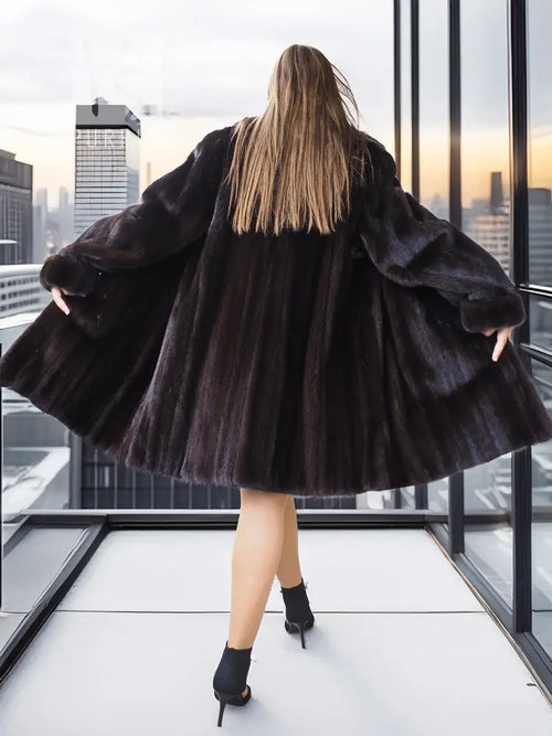 Reversible mink jacket, back view with wide flared hem and dark fur trim over sleeves