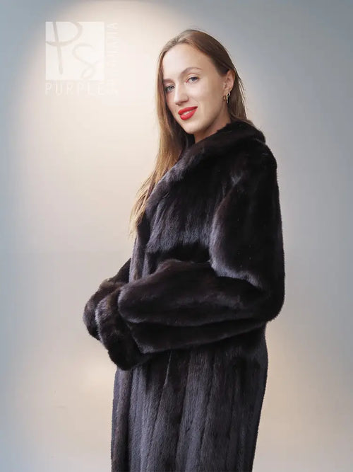 Reversible mink jacket with dark fur front, button placket, and wide padded sleeves