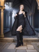 Dark lamb fur coat with fur collar and button front, worn over black dress