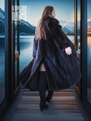 Black mink coat over black dress with back slit, side view, tall boots