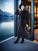 Black mink coat ensemble with beret, long fur coat and black handbag, standing by an open door