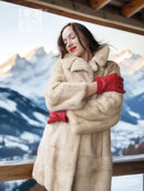 Light beige mink fur coat with raised collar and red fingerless gloves
