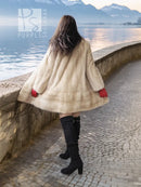 Cream faux fur coat with red cuffs and full length swing hem, worn with black boots