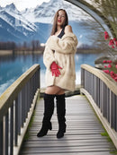 Cream faux mink fur coat with red cuff details, worn with black knee-high boots