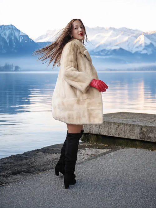 Light beige mink fur coat worn outdoors, red fingerless gloves and black boots