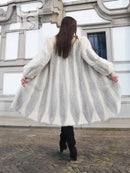Full-length cream mink coat with chevron pattern, wide flared back hem, plush collar