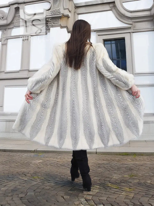 Full-length cream mink coat with chevron pattern, wide flared back hem, plush collar