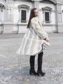 Full-length mink coat in light cream with chevron herringbone texture, walking view