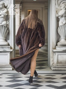 Long mink fur coat with loose fit and wide sleeves, open front design.
