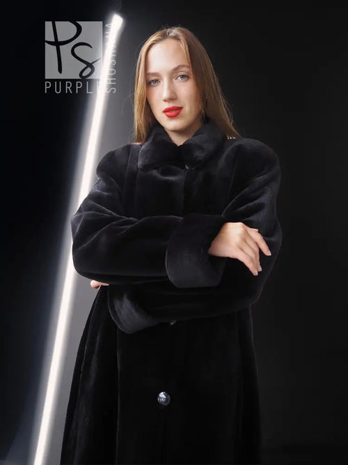 Reversible sheared mink coat in dark black with button-front and standing collar, portrait close-up.
