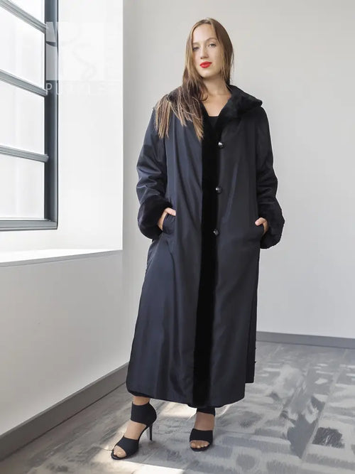 Long black mink coat with button front and full sleeves, front view