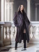 Long beaver fur coat in dark tone with fox-fur collar, cuff trim, and button front.