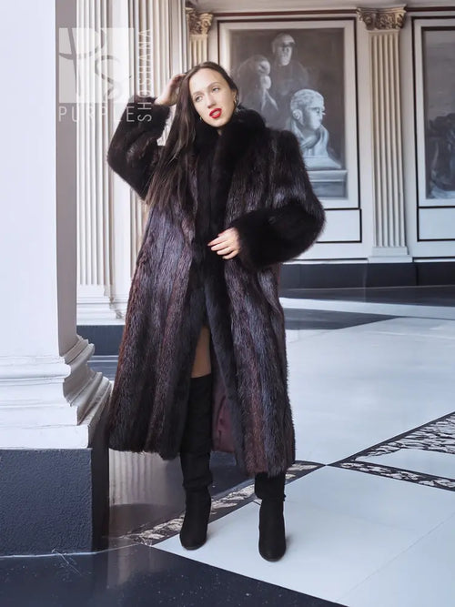 Long dark fur coat with voluminous sleeves and open front over a black dress