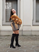 Fox-fur style jacket in orange-brown and gray with plush collar, worn with black boots.