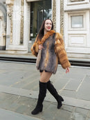Fur jacket with orange and grey diamond panels and big, rounded collar.
