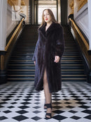 Black mink full-length coat with side-slit hem and structured, textured fur finish.