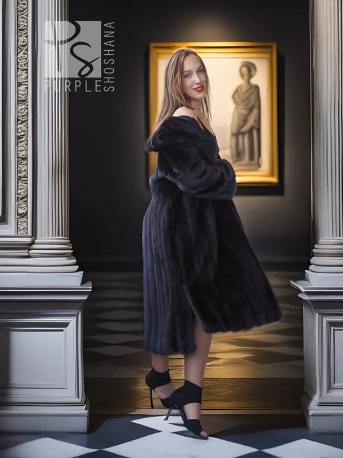 Black mink full-length coat with V-neck, hood, and flared, textured fur body.